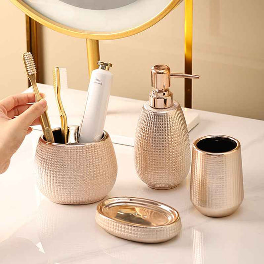 Bathroom accessories set with toothbrushes, soap dispenser, and cups on a light surface.